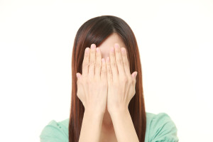 目を塞ぐ女性