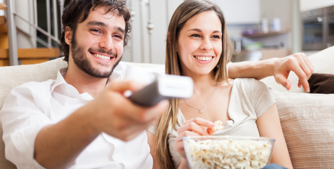 家で映画を見るカップル